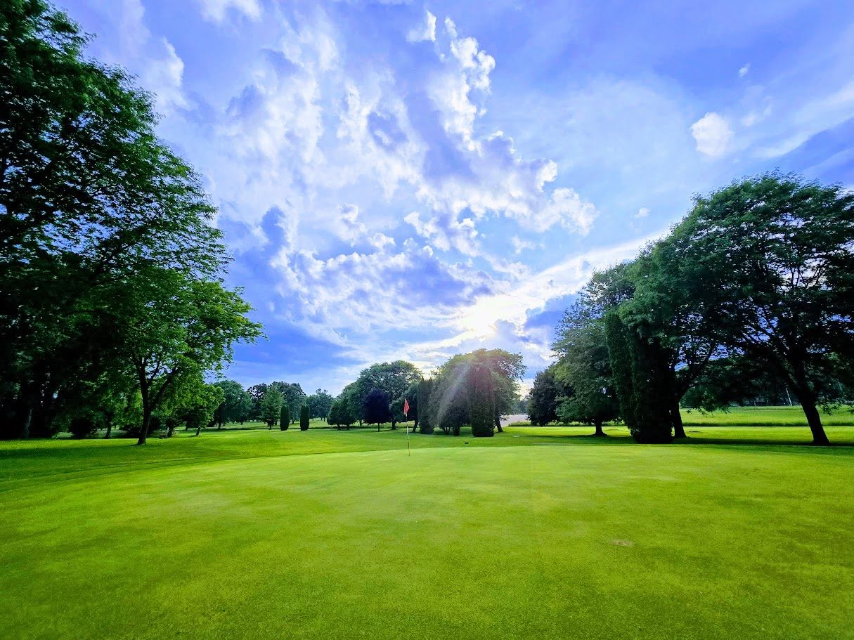 A putting green framed by mature trees at Columbus Country Club