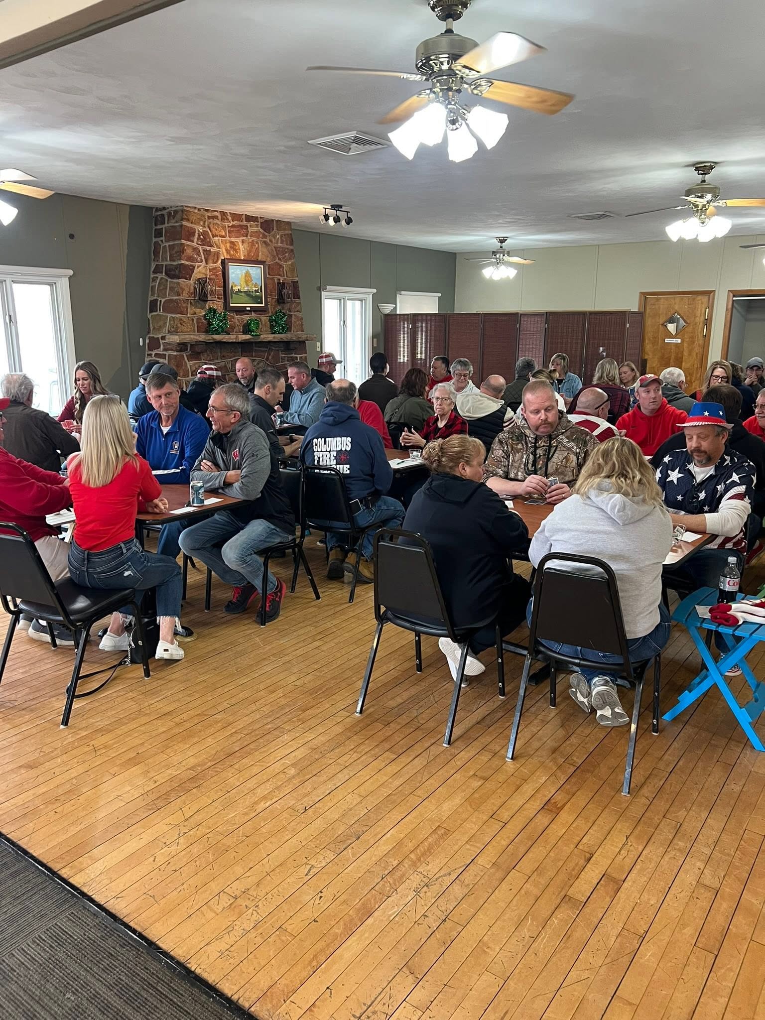 Guests seated at tables beside the stone fireplace in the Columbus Country Club clubhouse