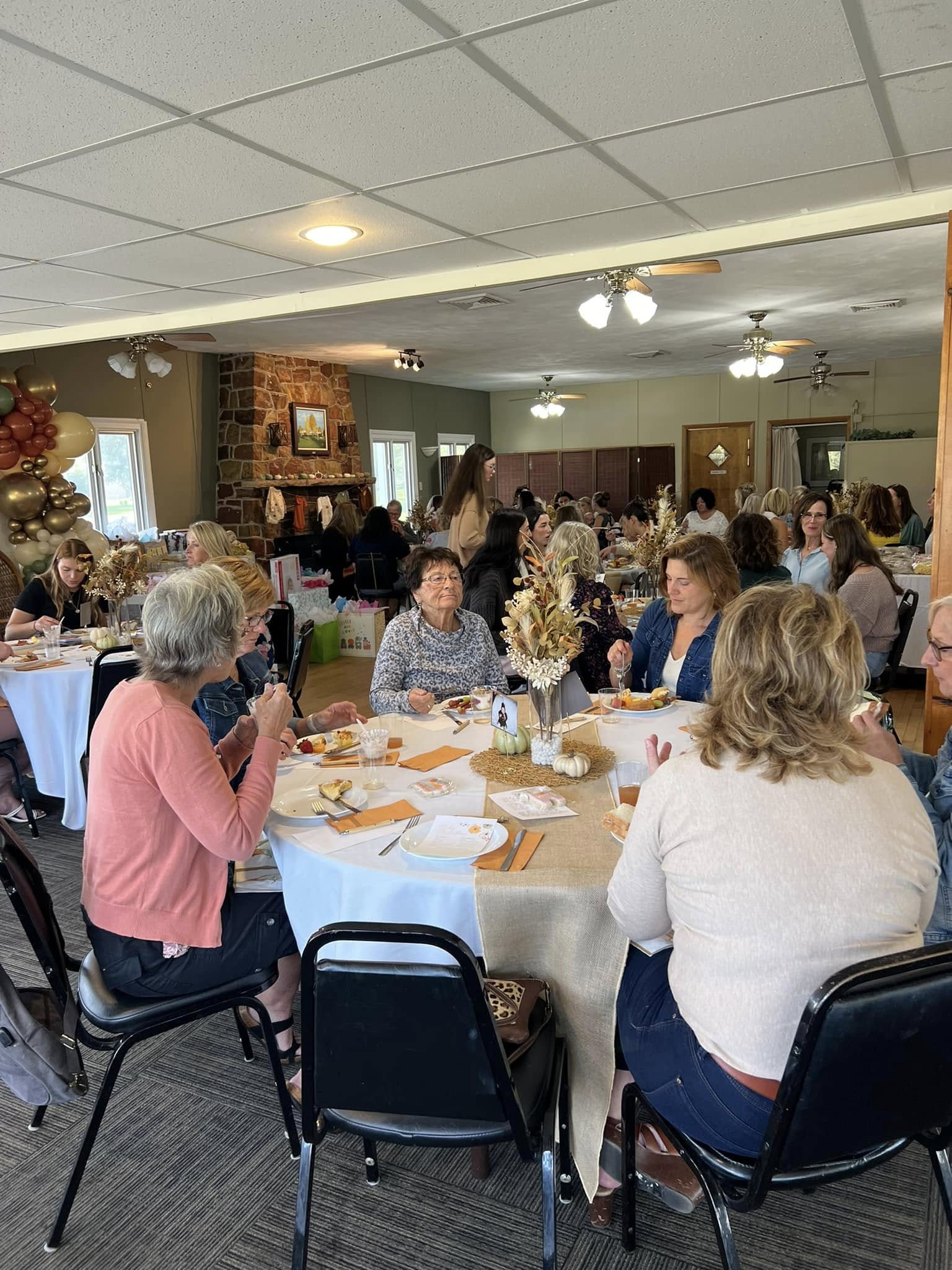 Guests gathered around decorated tables in the Columbus Country Club clubhouse